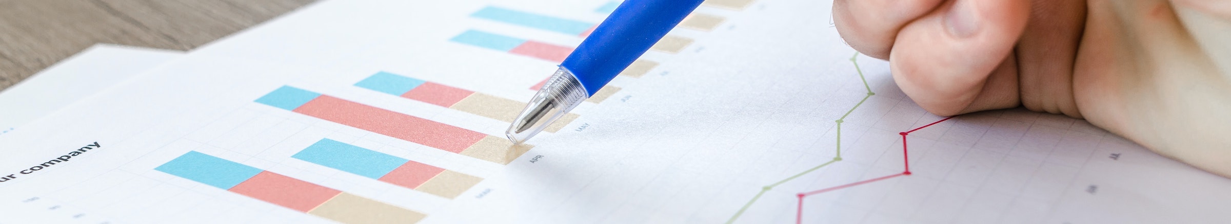 Hand with pen and charts